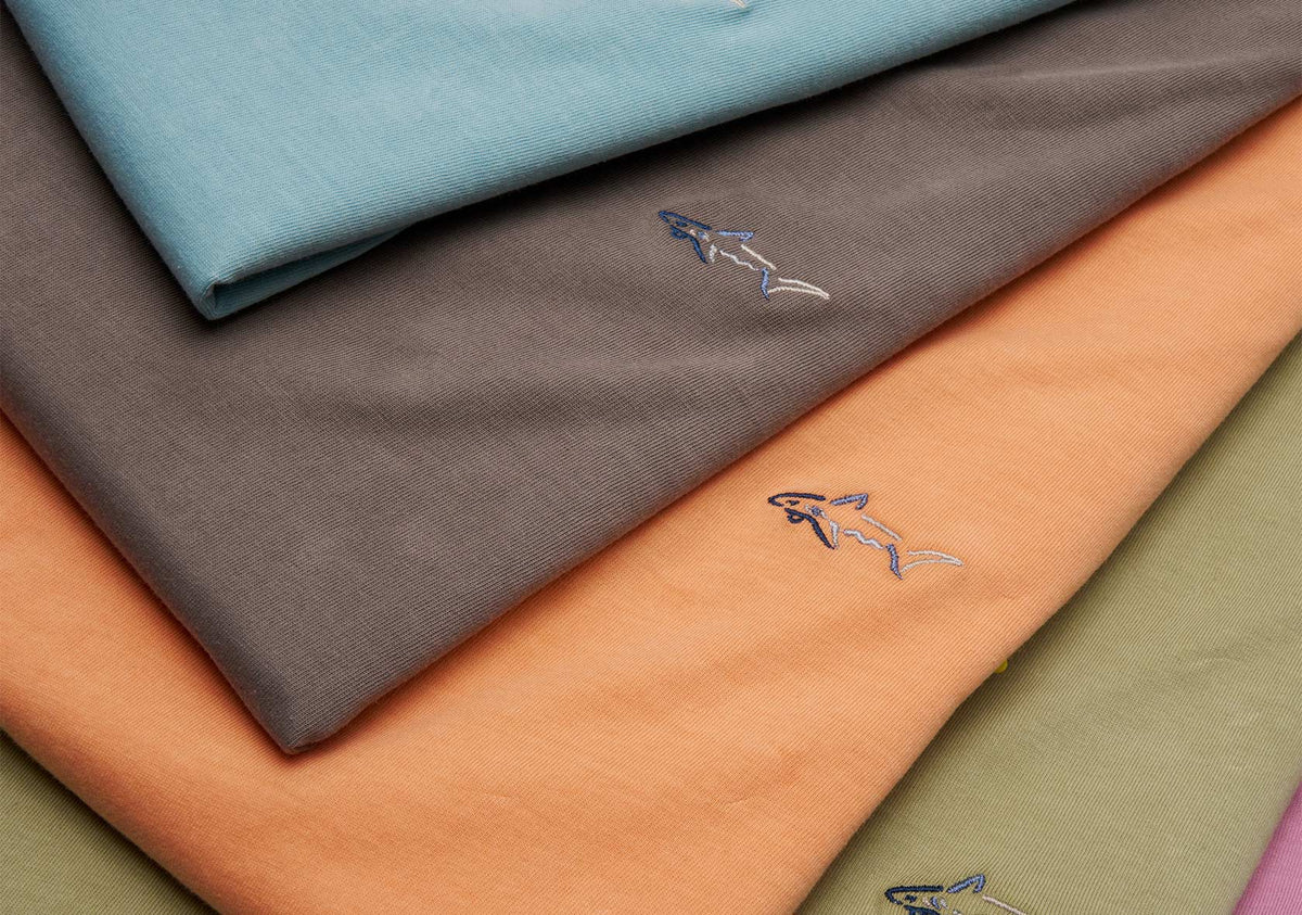 Greg Norman Collection golf polos showing Shark logo and fabric colors